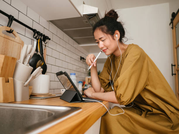 donne asiatiche freelance che lavorano in cucina. - lifehack foto e immagini stock