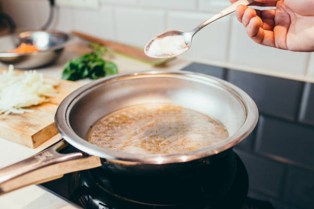 hack di vita in cucina - come pulire la padella dai depositi di carbonio - un cucchiaio di bicarbonato di sodio in acqua bollente - lifehack foto e immagini stock